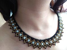 a woman wearing a black and gold beaded necklace