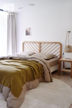 a bed sitting in a bedroom on top of a wooden floor next to a window