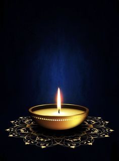 a lit candle sitting on top of a table next to a doily with an intricate design