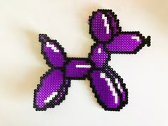 a purple and black pixelated animal sitting on top of a table