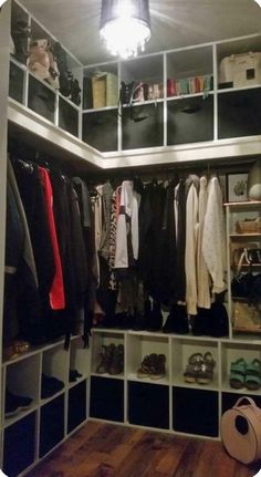 an organized closet with clothes hanging on shelves and shoes sitting on the floor in front of it