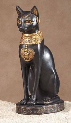 an egyptian cat statue sitting on top of a table