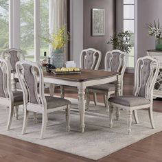 a dining room table and chairs in front of a window