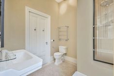 a bathroom with a sink, toilet and shower stall in the middle of the room