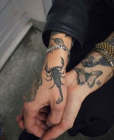 a man with tattoos on his arm holding onto another person's hand