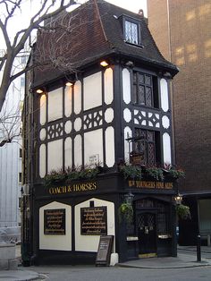 an old building that has been converted into a restaurant with flowers growing on the windows