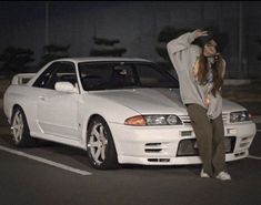 a person standing next to a white car