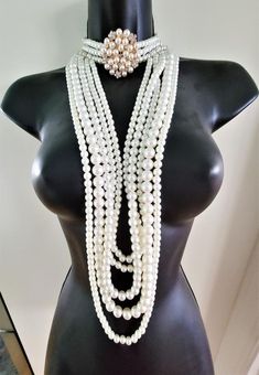 Hello, welcome to Ken's ClosetToday we have a beautiful Peral Body Crystal Choker Necklace.  This necklace has 3 strands of pearls on the choker. The choker has a beautiful ornament, that is a mix of pearls and crystals. The necklace is 15" long with a 2" adjustable chain. The total length that would hang in the front is 19" The dangling section is made of 5 stands in different size pearls and staggered lengths. This set is very sparkly and would look great on any stage or special event.Crystals Multi-strand Pearl Necklace For Party, Costume Multi-strand Pearl Necklace For Party, Gold Pearl Necklace With Chain, Costume Jewelry, Queen Mermaid, Evening Multi-strand Pearl Necklace, Pearl Necklace With Rhinestones, Costume Jewelry Style, Luxury Multi-strand Pearl Necklace With Pearl Chain, Pearl Multi-strand Costume Jewelry Necklace, Luxury Multi-strand Pearl Necklaces