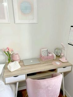 a desk with a laptop, pink chair and pictures on the wall in a bedroom