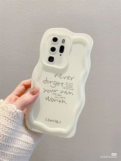 a person holding up a cell phone case with writing on it