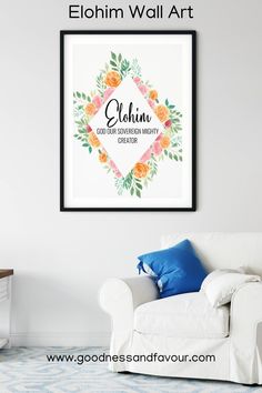 a white couch sitting next to a wall with a framed poster above it that says, elohim wall art