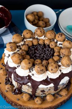 a cake with chocolate chip cookies and cream frosting sitting on top of a blue table