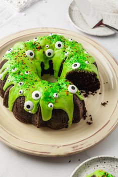 a chocolate cake with green frosting and eyes on the top is ready to be eaten