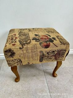 a small stool with a floral design on it's seat cushion is shown in front of a white wall