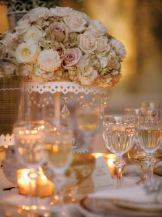 the centerpieces are adorned with white flowers and candles for an elegant touch to the table