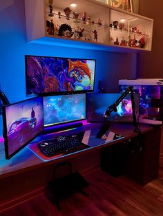 a computer desk topped with three monitors and a keyboard