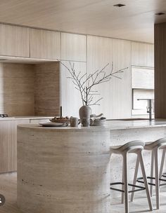 an island in the middle of a kitchen with stools