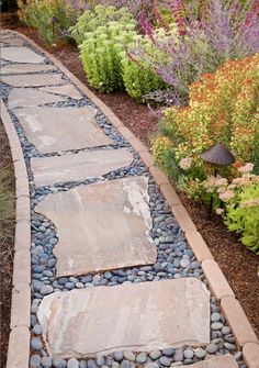 a stone path in the middle of a garden