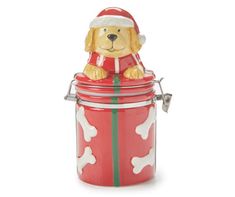 a dog sitting on top of a canister with a santa hat and bone pattern