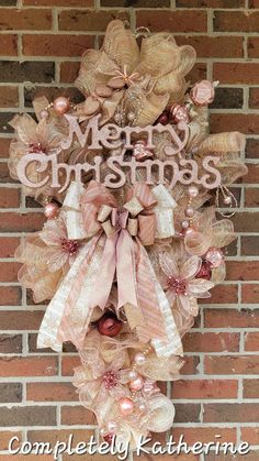 a christmas wreath hanging on the side of a brick wall with words merry christmas written in it