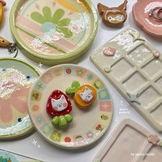 some toys are sitting on a table with plates and trays in the shape of animals