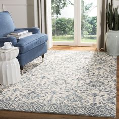 a living room with a blue chair and white rug