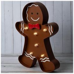 a lighted gingerbread man with a red bow tie and light bulbs on it's chest