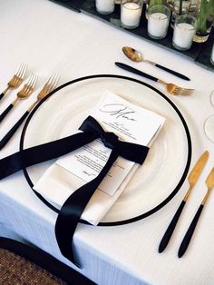 a place setting with silverware and black ribbon