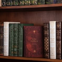 a row of books sitting on top of a wooden book shelf next to each other