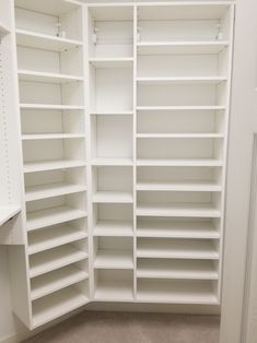 an empty closet with white shelving in the corner and carpeted flooring on the other side