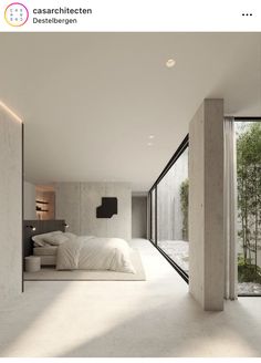 a bedroom with white walls and flooring next to a large glass window that overlooks trees