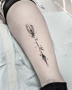 a woman's arm with a tattoo on it that has an arrow and stars