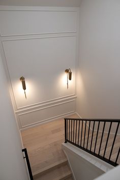 an empty staircase with two lights on the wall