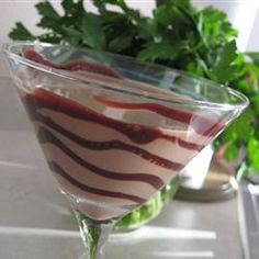 a dessert in a martini glass on a table next to a potted leafy plant