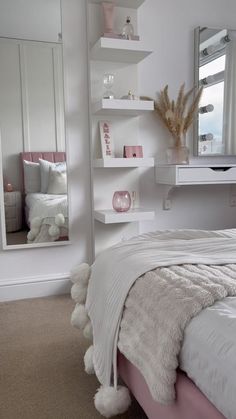 a bedroom with a bed, mirror and shelves