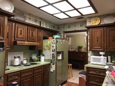 a kitchen filled with lots of wooden cabinets and green counter tops, along with a refrigerator freezer