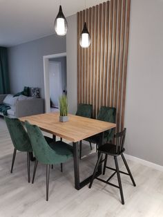 a dining room table with green chairs and a plant in a vase on the end