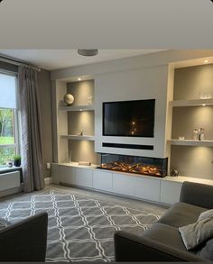 a living room with couches and a flat screen tv mounted to the side of a wall