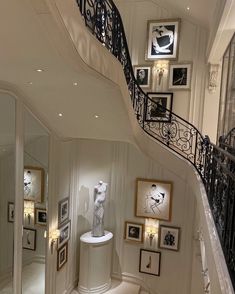 a staircase in a home with pictures on the wall and framed photographs on the walls