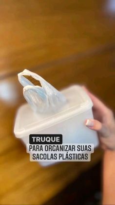 a person holding a plastic container with tissue on it and the words truque para organizar suas saculas plasticas