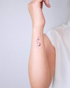 a woman with a small star and moon tattoo on her arm