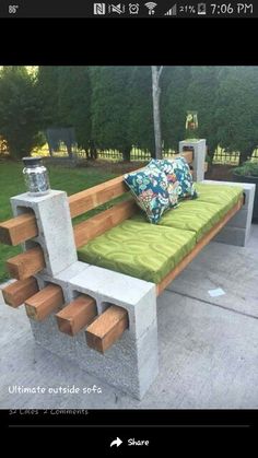 a bench made out of concrete blocks with green cushions