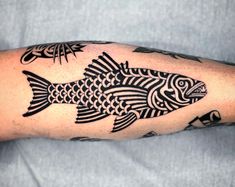 a man's arm with a fish tattoo on it