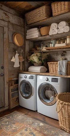 a washer and dryer in a small room with baskets on the shelves next to it