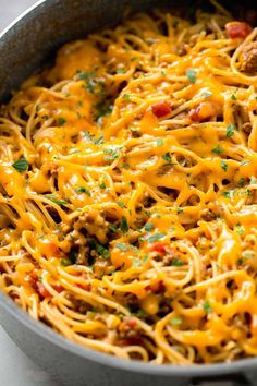 a skillet filled with spaghetti and meat