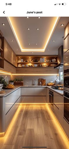 a kitchen with wooden floors and lights on the ceiling, along with white cabinets and counter tops