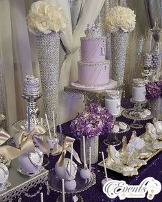 a table topped with lots of purple and white cakes