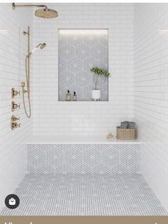 a white tiled bathroom with a shower, sink and mirror above the bathtub is a plant