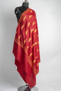 This deep red merino wool shawl features a stunning spread of Sozni hand-embroidered paisleys in golden hues, each pattern meticulously placed to showcase the masterful craftsmanship of Kashmiri artisans. The balanced use of intricate motifs against the bold red fabric lends an air of classic charm to the piece. Perfect for special occasions or as a statement wrap on chilly evenings, this shawl adds both warmth and sophistication to your look. The luxurious feel and exceptional embroidery make i Luxury Embroidered Red Pashmina Shawl, Luxury Shawl With Intricate Embroidery, Embroidered Rug, Scarf Jacket, Embroidered Handbag, Silk Carpet, Wool Shawl, Pashmina Shawl, Embroidered Bag