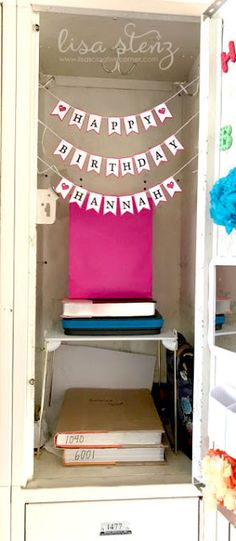 an open cabinet with a birthday banner hanging from it's front and back doors